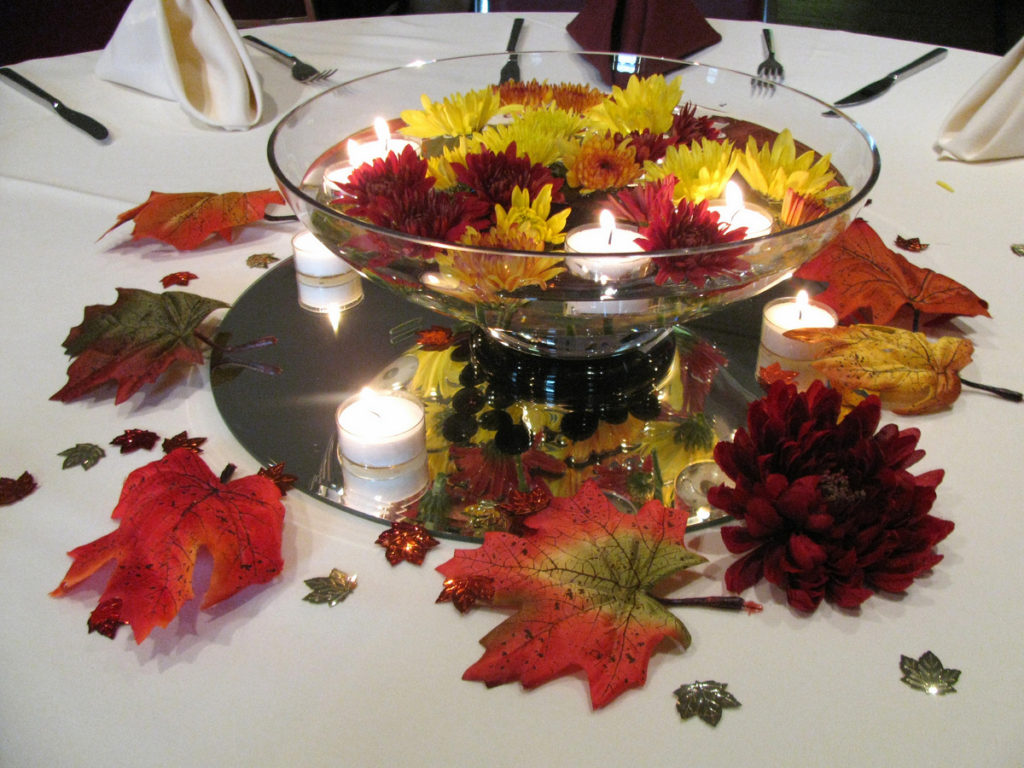 Glass centerpiece with and floating flowers and candles