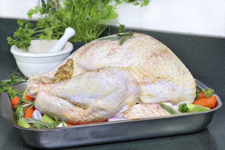Whole raw turkey, dressed with butter, spices and surrounded with veggies - oven ready | MakeItGrateful.com