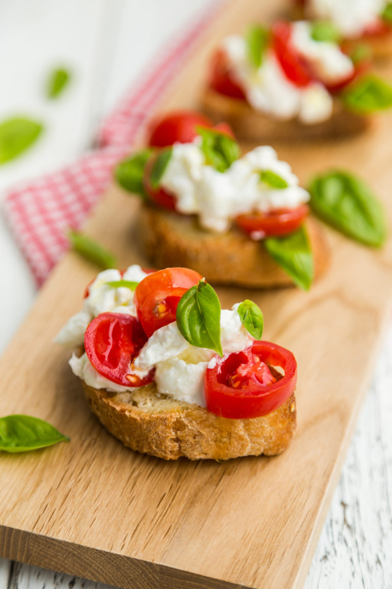 Crostini with soft cheese, fresh tomatoes and basil