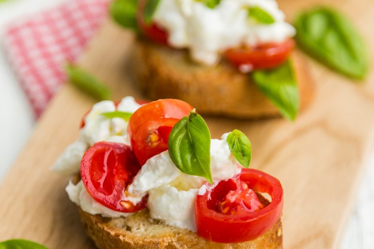 Crostini with soft cheese, fresh tomatoes and basil
