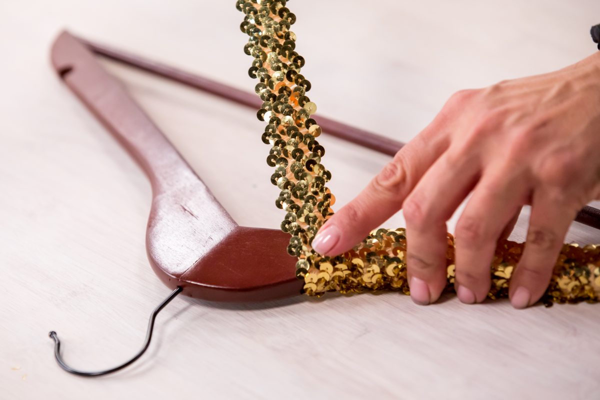 Adding sequins to a wooden hanger