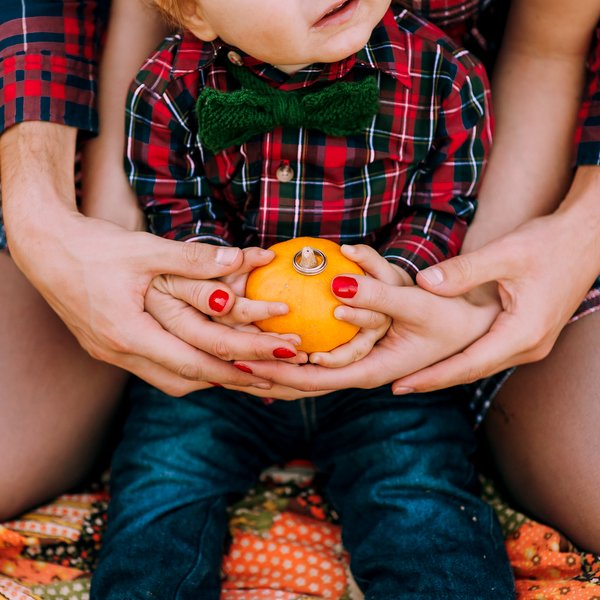 Toddler holding small pumpkin