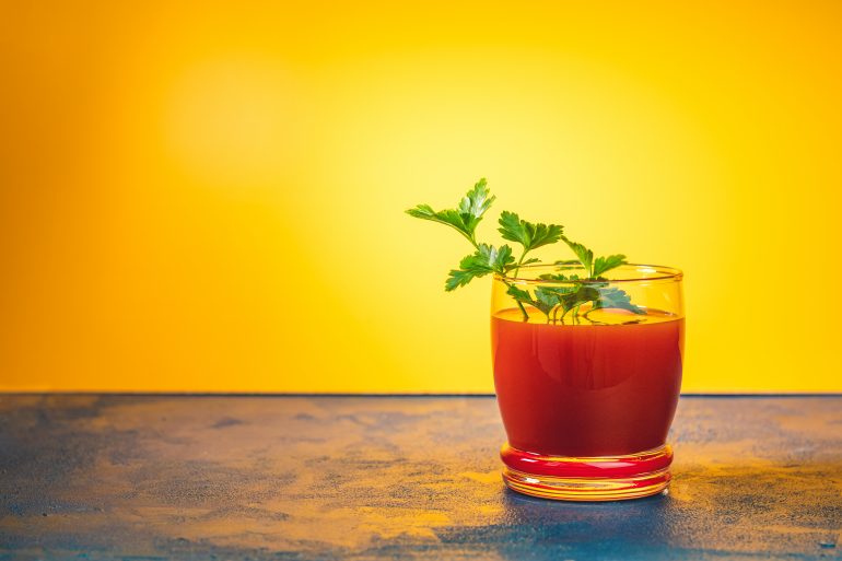 Delicious tomato bloody mary cocktail on dark blue concrete table