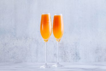 two glasses of fruit champagne on the table. refreshing festive cocktail