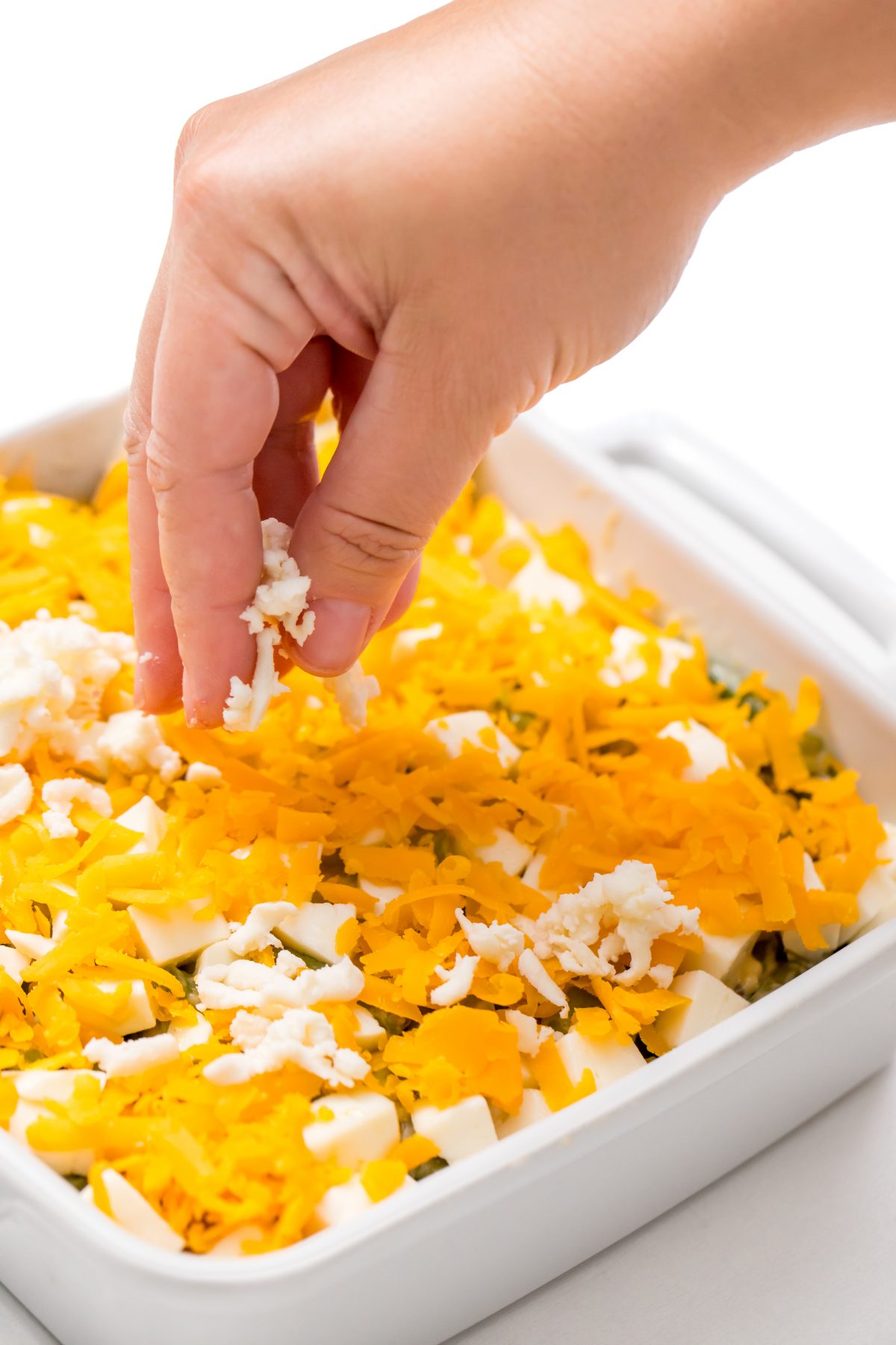 Top the casserole with more shredded cheddar and mozzarella cheese.
