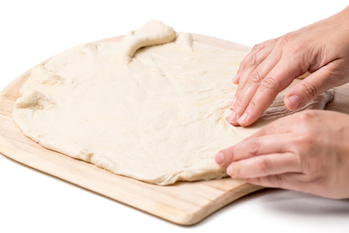 Stretch dough to outer edges for Bobby Flay's Margherita grilled pizza