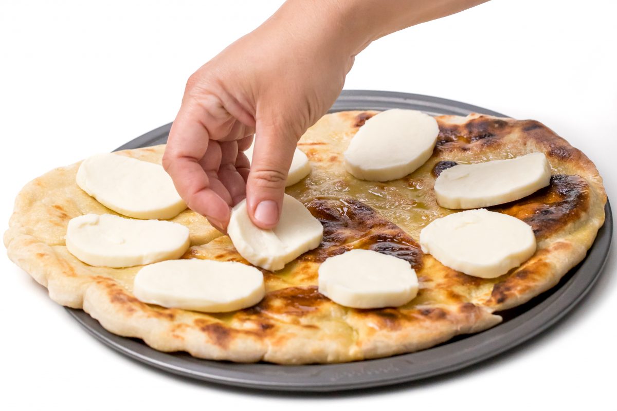 Top with fresh mozzarella for Bobby Flay's Margherita grilled pizza