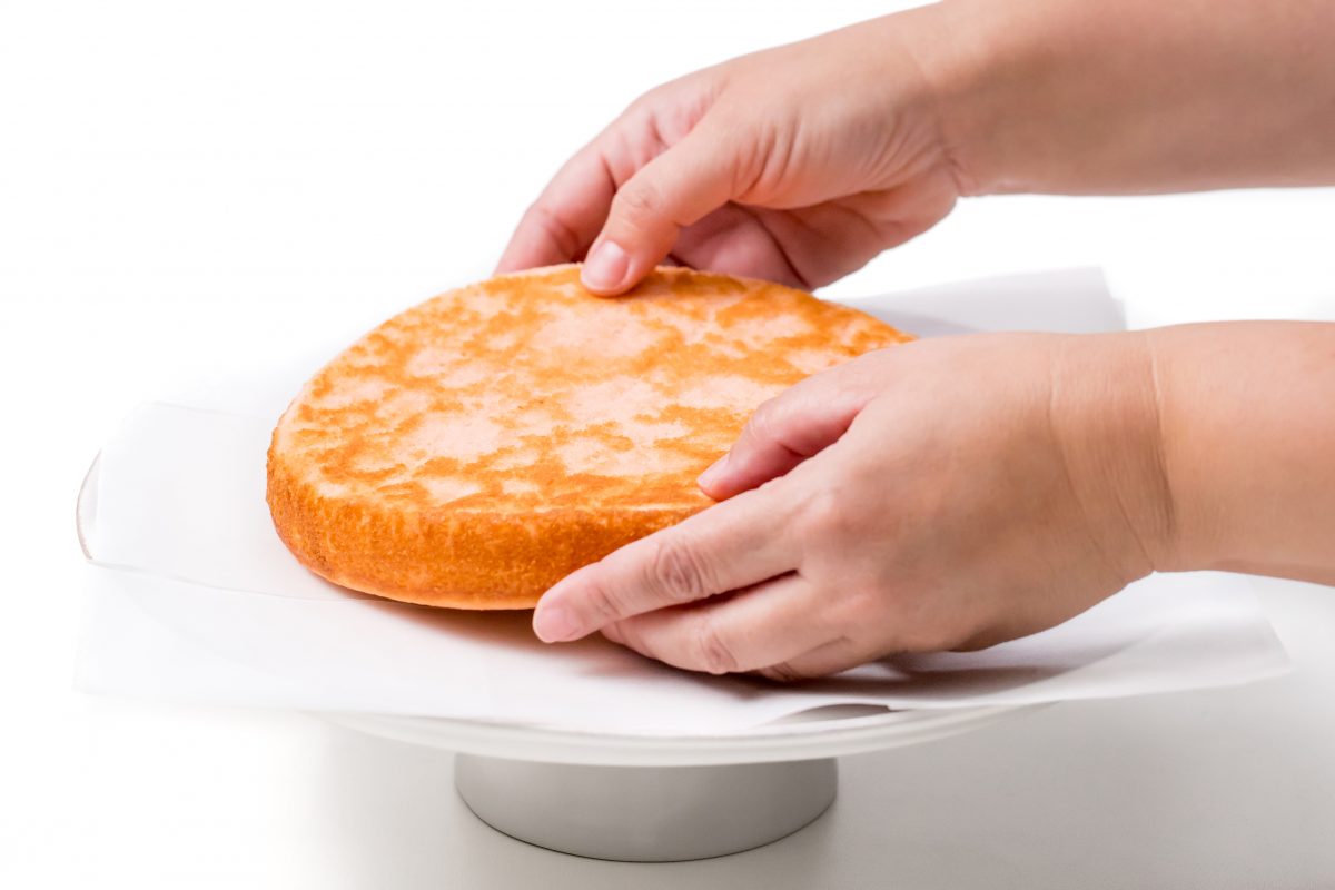 Place first cake layer onto frosting on cakestand