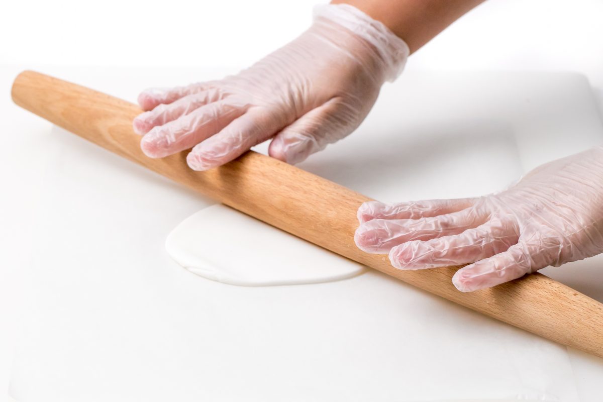 Roll out white fondant with rolling pin for pink unicorn cake