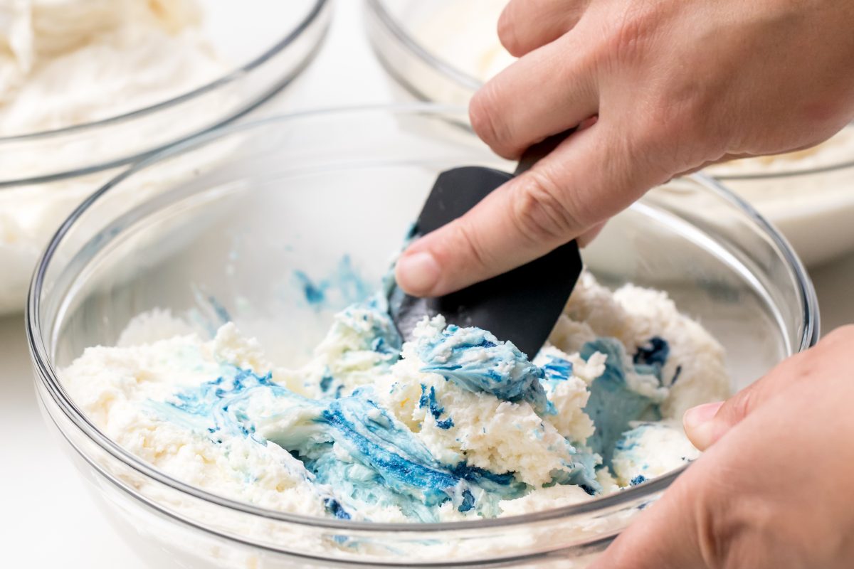 Add blue food coloring to one bowl