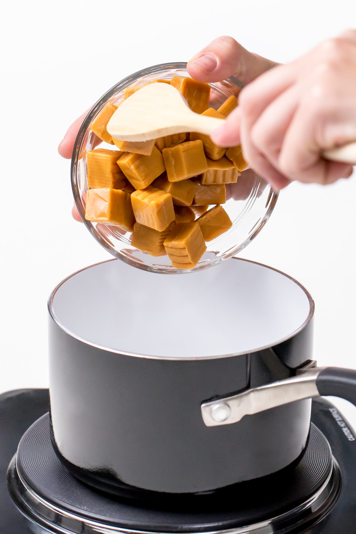 Pour caramel cubes into hot sauce pan