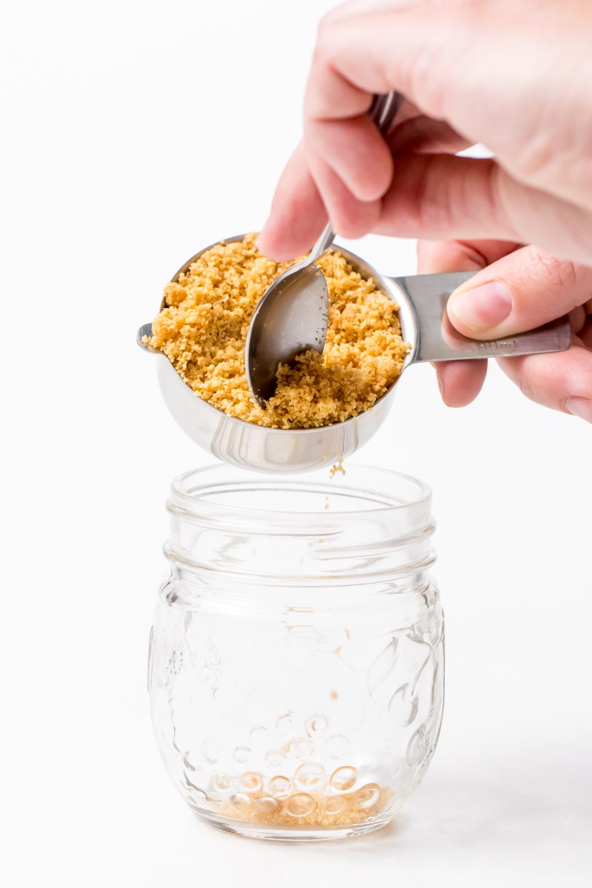 Spoon crushed graham crackers into the bottom of a mason jar