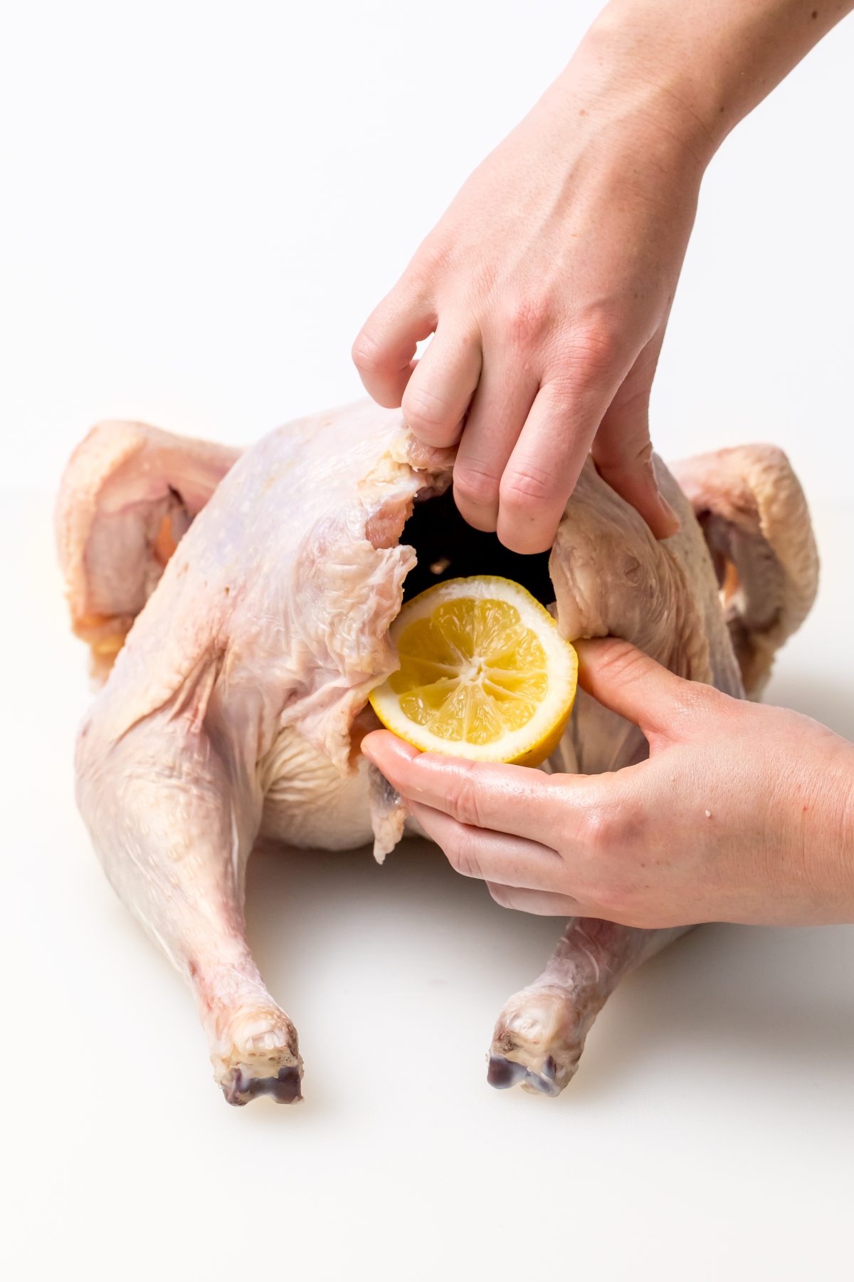 5D4B2276 - James Beard Roasted Turkey - inserting lemon into turkey cavity