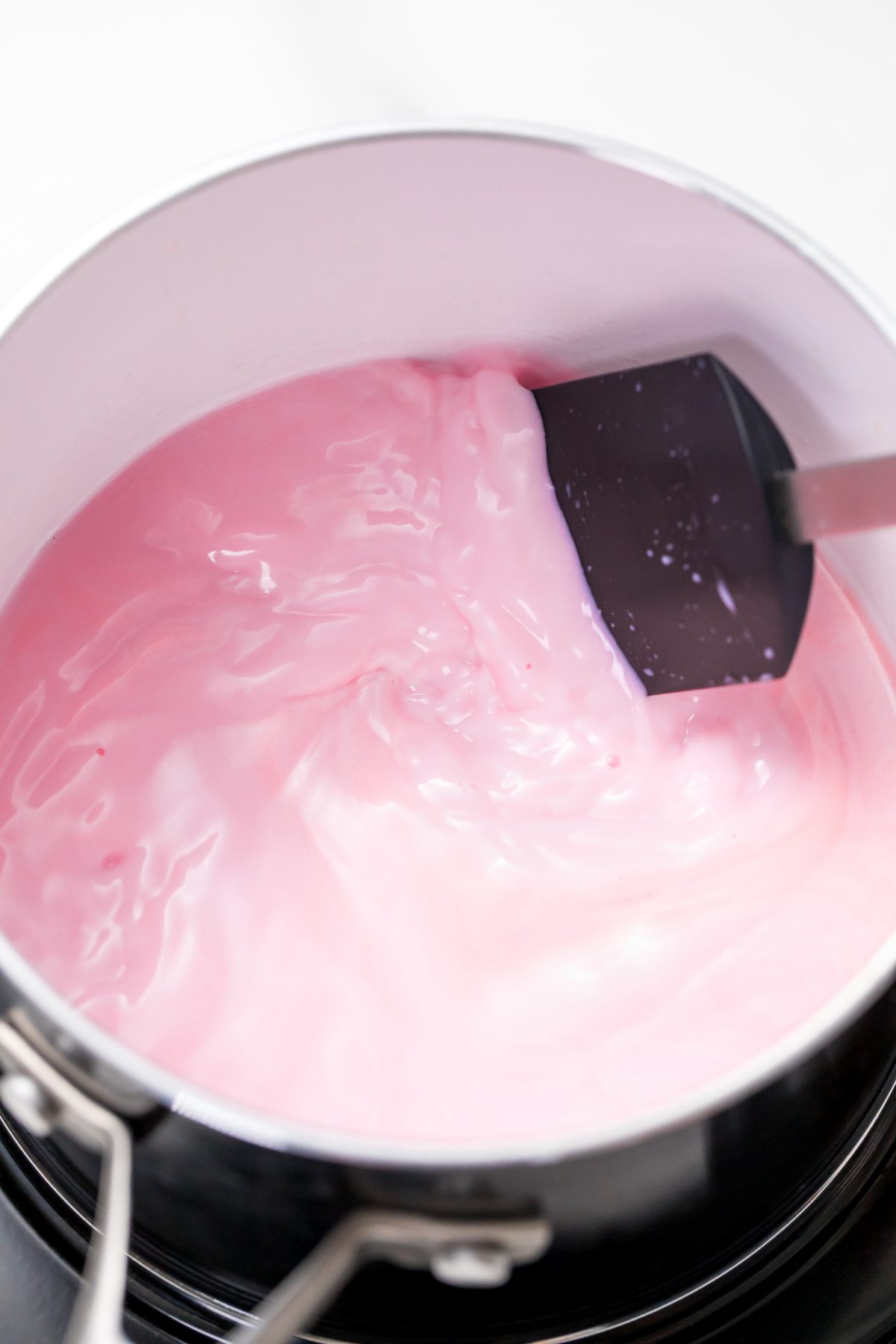 5D4B2998 - Unicorn Hot Chocolate - mixing milk with food coloring using a spatula in a pot