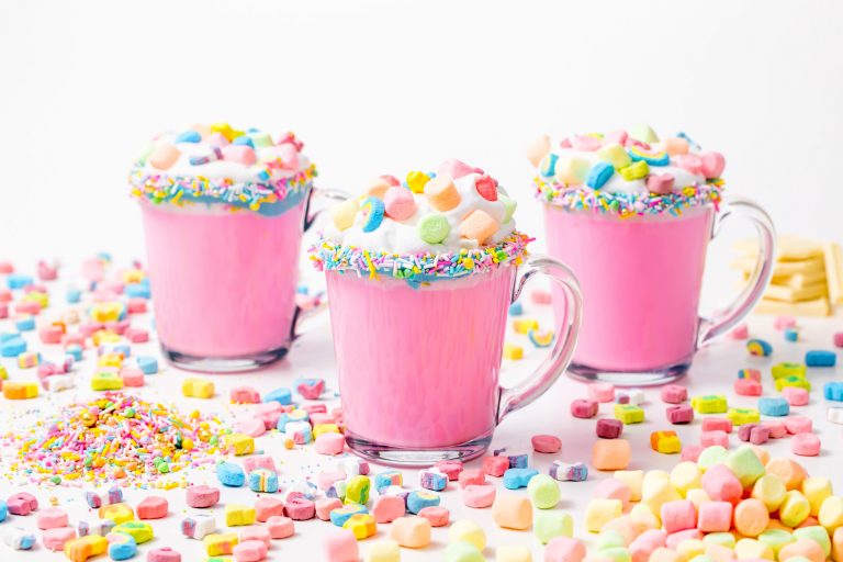 5D4B3097 - Unicorn Hot Chocolate - pink hot chocolate with whipping cream, lucky charms marshmellows on a white table