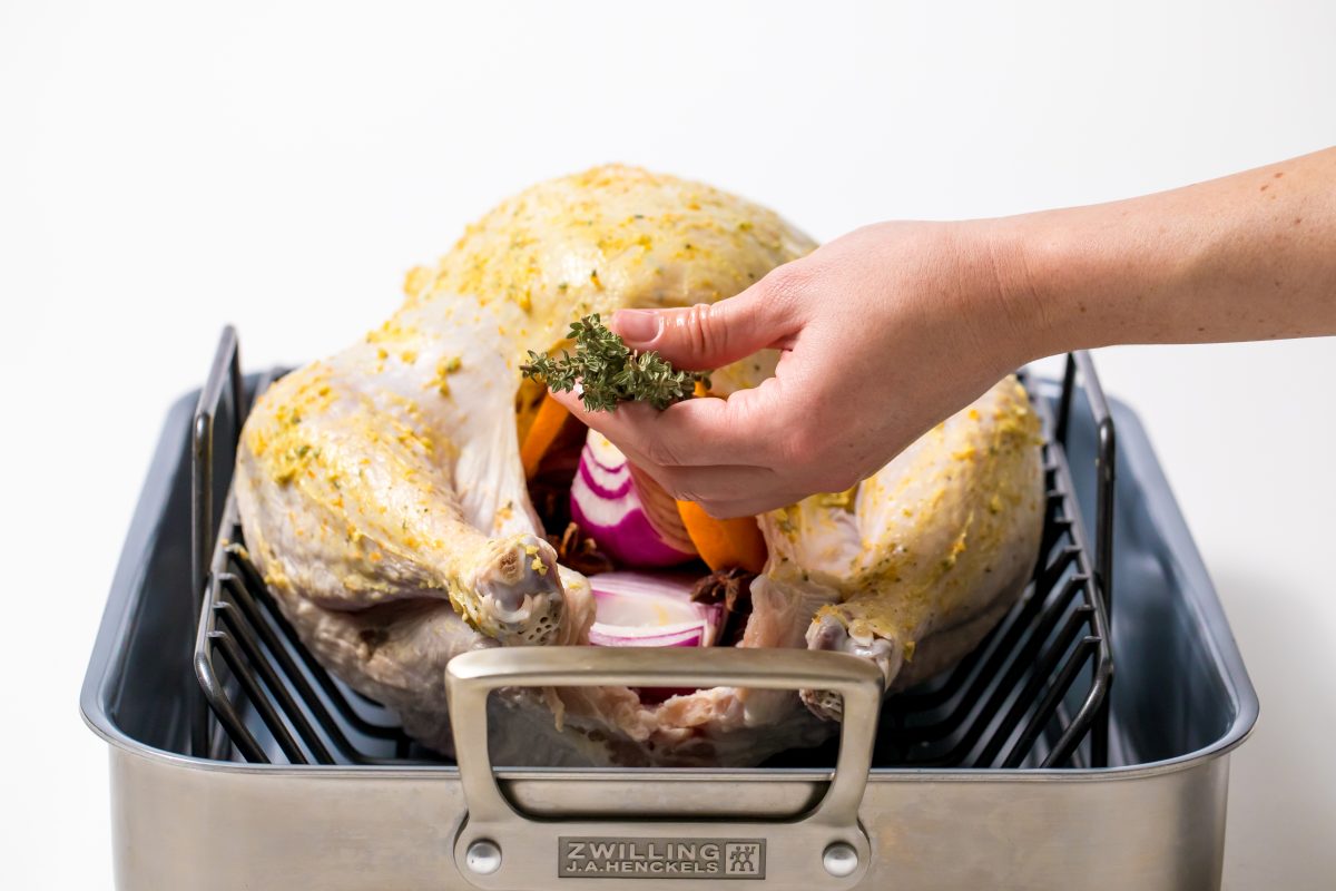 5D4B6990 - Orange Anise and Thyme Turkey - inserting thyme into cavity of turkey