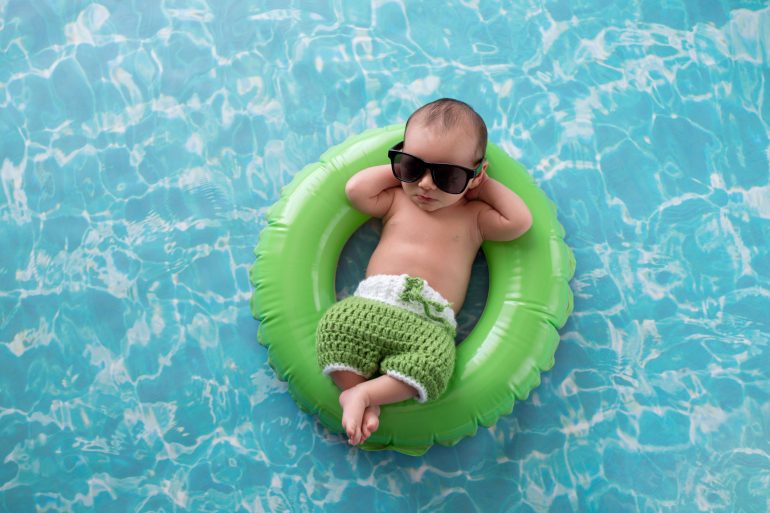Baby floating on a green swim ring