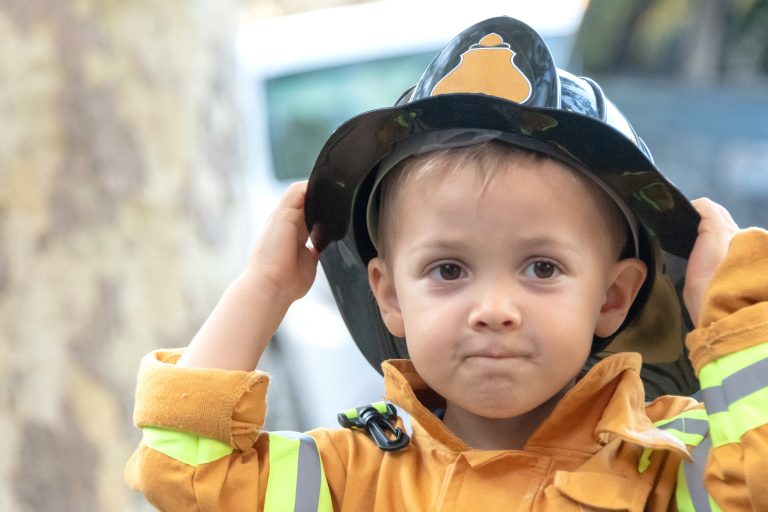 toddler posing wearing a firefighter costume