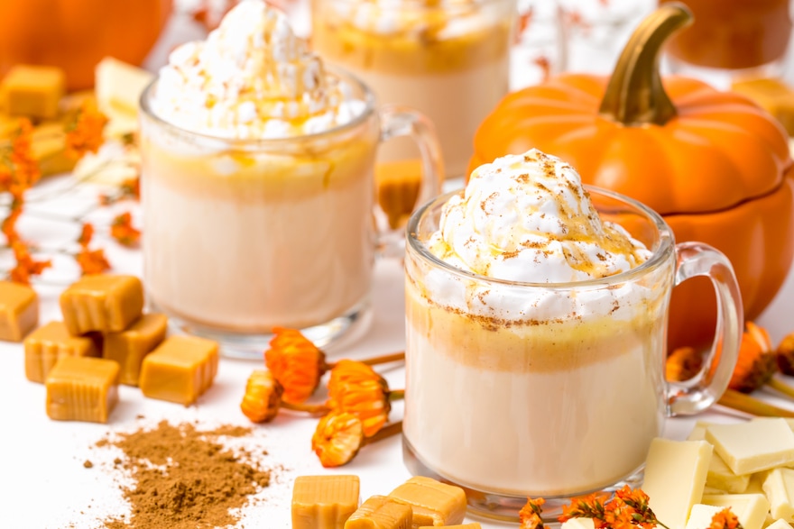 5D4B7327-Boozy-Pumpkin-Hot-Chocolate-served-hot-pumpkin-spice-on-a-white-table-surrounded-by-caramels-pumpkin-spice-and-pumpkins