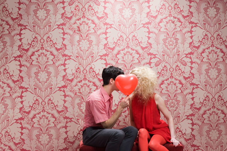 Couple behind heart shaped balloon