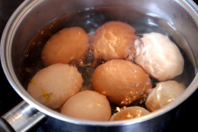 Image of chicken eggs boiling in saucepan, boiling water, simmering