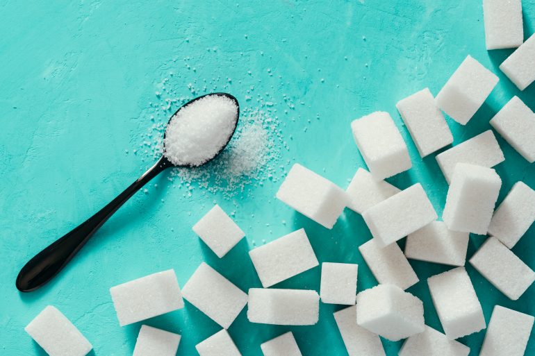 Top view of white sugar cubes on turquoise background